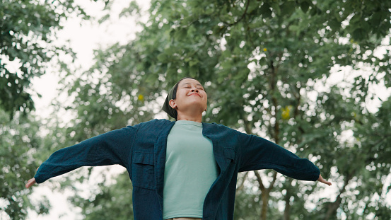 Person breathes deeply in a park, free of sinus concerns.